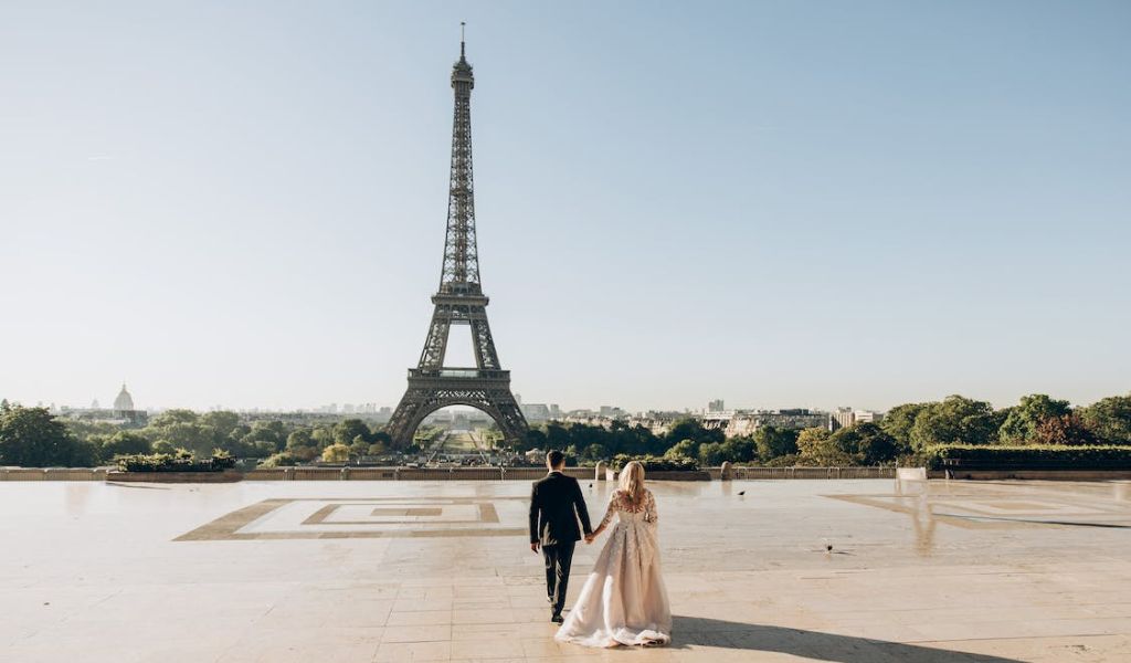 A Newly Wed Walking in Park in Front of Eiffel Tower