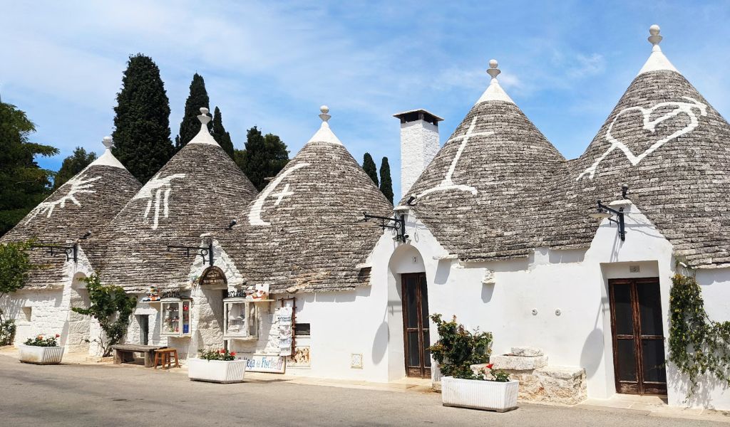 Trullo houses with different symbols on top of the roof are located in Alberobello.