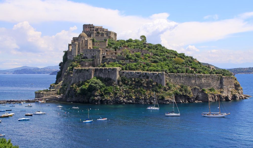 Tourists visit The Aragonese Castle in Ischia using private boats.