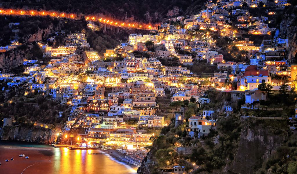 Nighttime view of a cliffside village located in Positano.