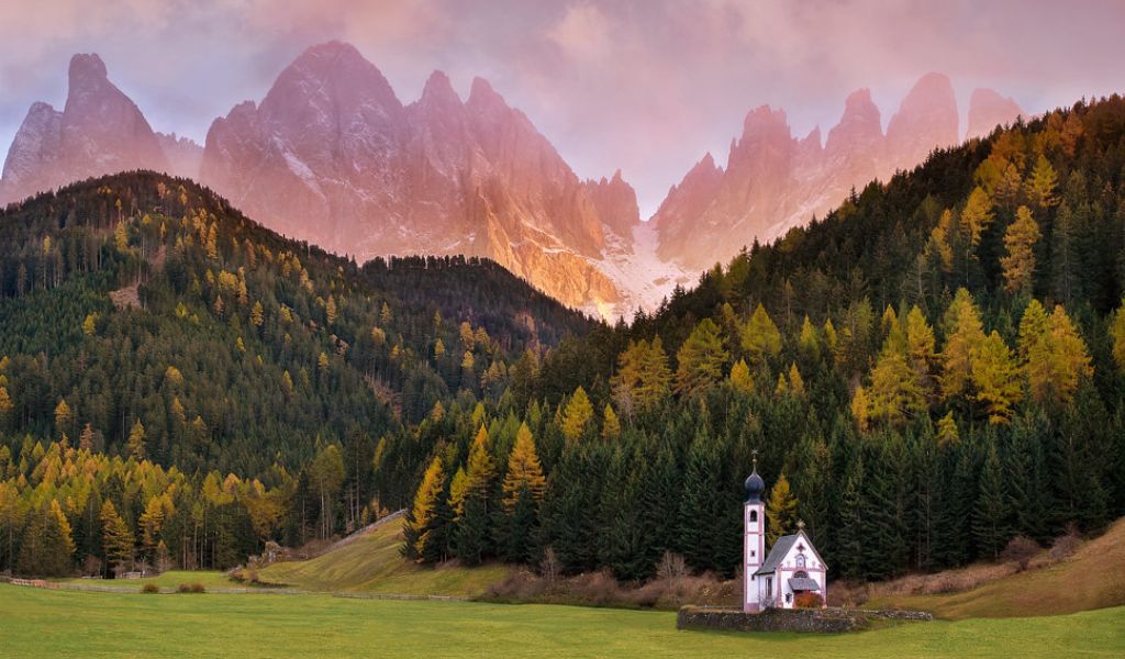 The small San Gionvanni church and dolomites mountain on the background.