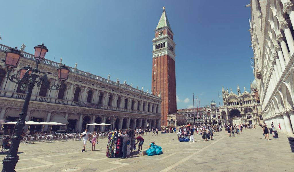 Tourists visit the famous Piazza San Marco in sunny weather.