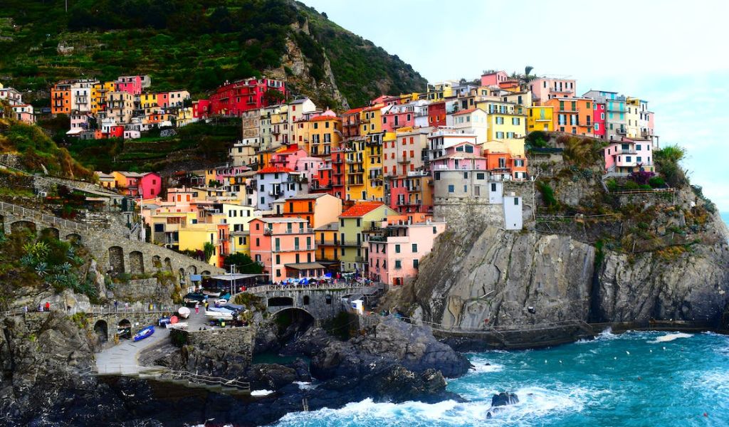 An Aerial Photography of Colorful Houses on a Mountain Near the Body of Water located on Cinque Terre