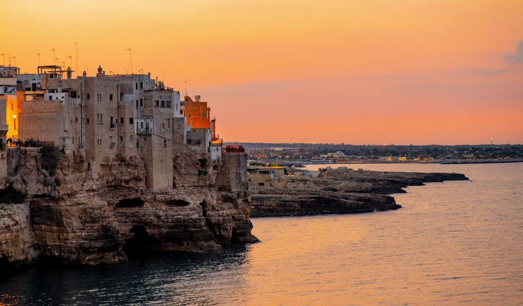 A beautiful view of the sea under the houses with sunset in Puglia.