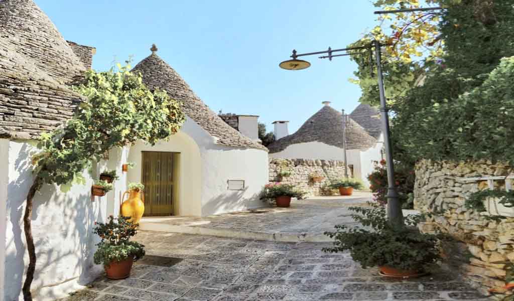 Structures made of white-washed stone and topped with conical roofs called Trulli in Alberobello, Puglia.
