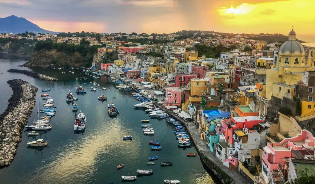 Aerial view of colorful houses near the sea with the beautiful sunset on Procida Island.