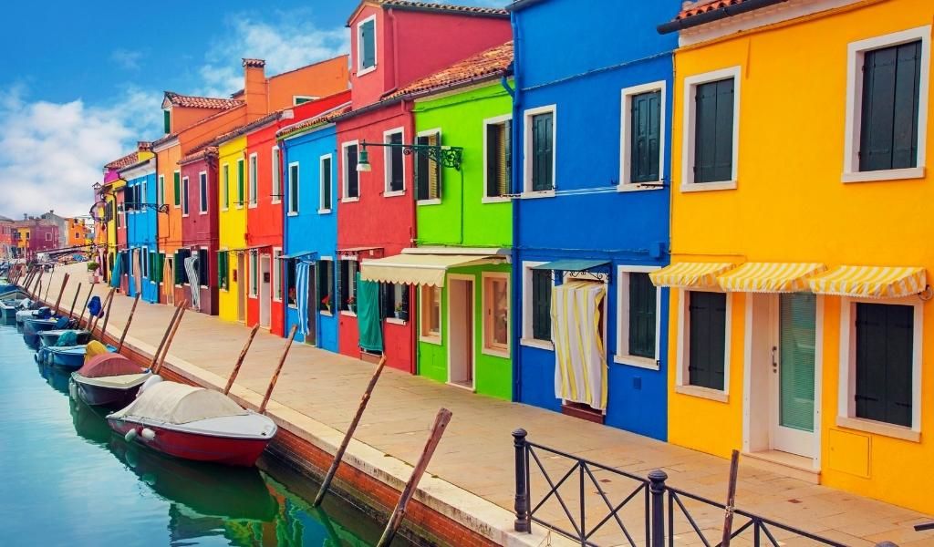 A boat parked in front of colorful houses in Grand Canal Venice.