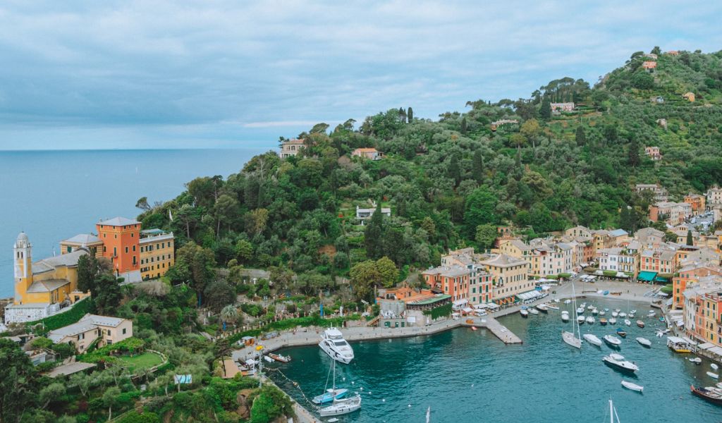 Aerial view of the Portofino shores with tourist boats and luxury hotels.